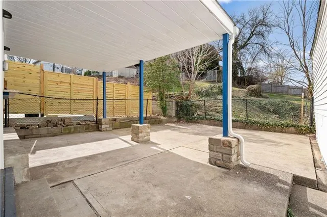 a view of a patio with a table chairs and a floor to ceiling window