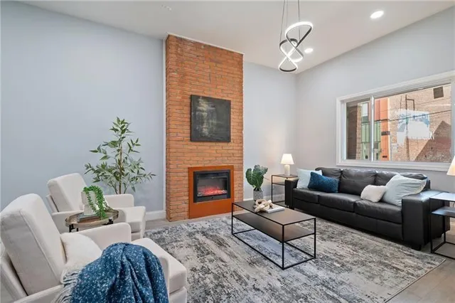 a living room with furniture a chandelier and a fireplace