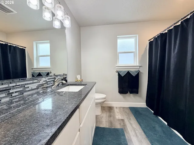 a bathroom with a granite countertop double vanity sink and a mirror