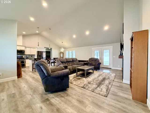 a living room with furniture and a refrigerator