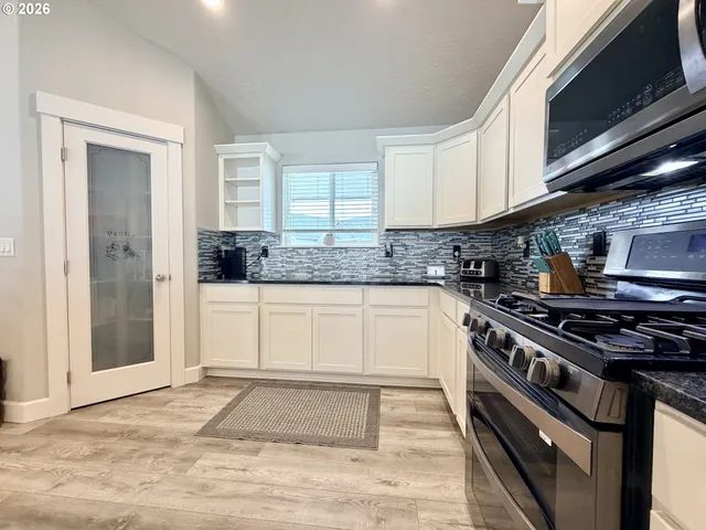 a kitchen with stainless steel appliances granite countertop a stove and a sink