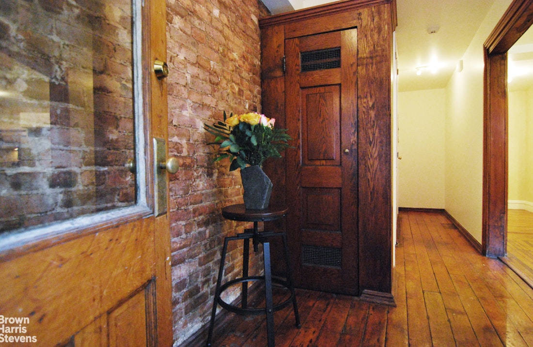 a view of a hallway with wooden floor and a potted plant