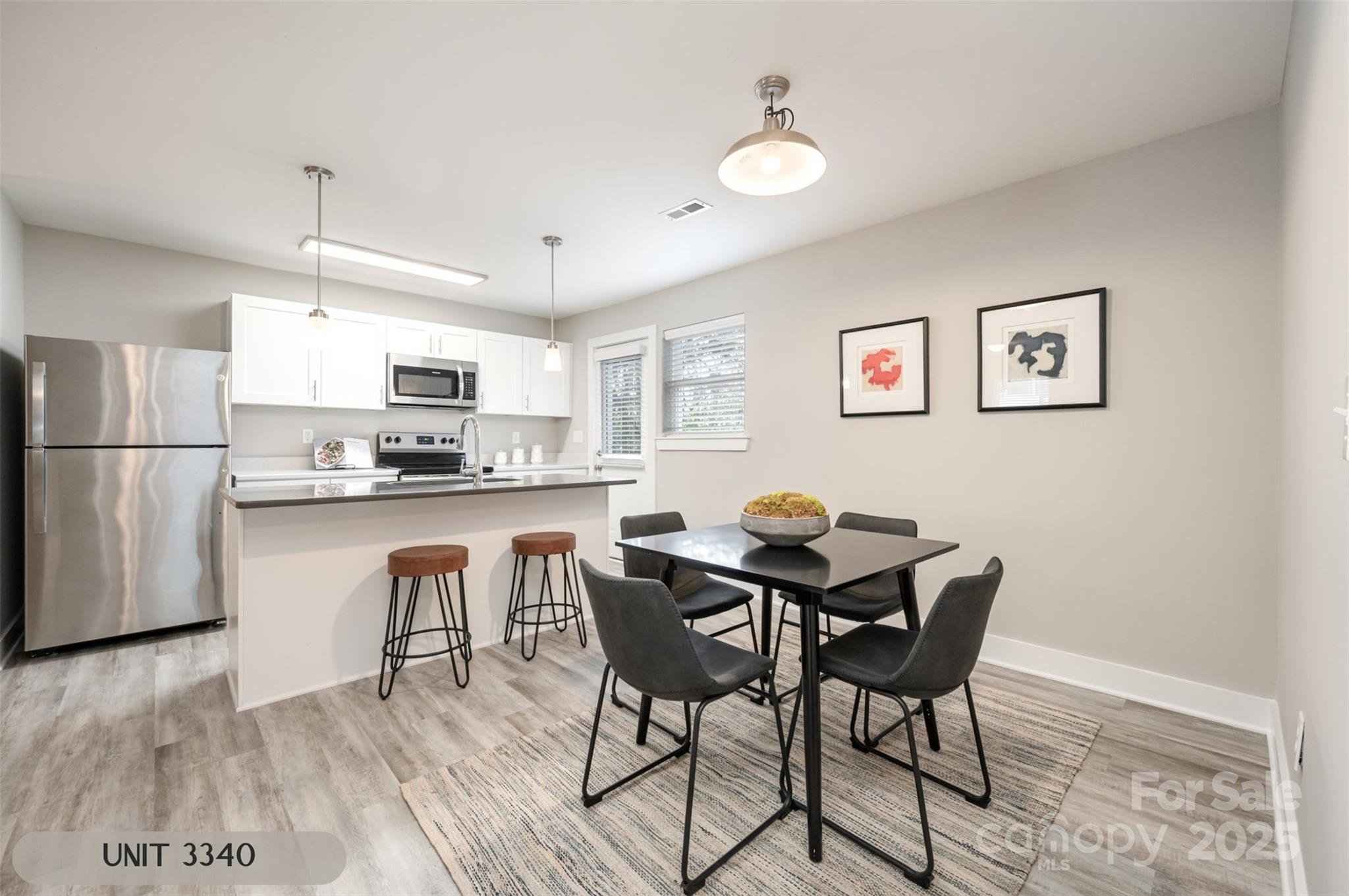 3342 Washburn Avenue Charlotte, NC 28205 - Photo 11 of 45 a kitchen with stainless steel appliances granite countertop a dining table chairs refrigerator and sink