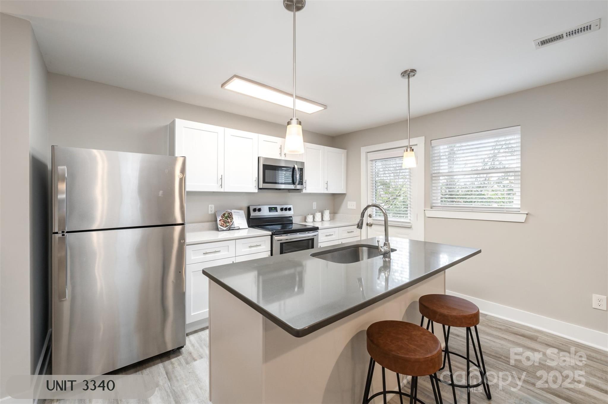 3342 Washburn Avenue Charlotte, NC 28205 - Photo 13 of 45 a kitchen with stainless steel appliances granite countertop a refrigerator a sink a stove a dining table and chairs