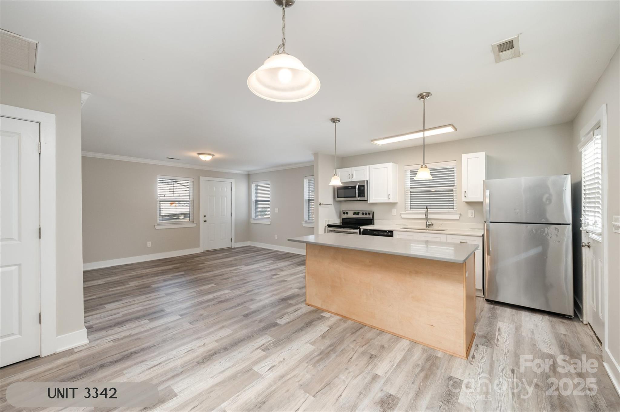 3342 Washburn Avenue Charlotte, NC 28205 - Photo 36 of 45 a kitchen with stainless steel appliances granite countertop a refrigerator a sink dishwasher a stove and white countertops with wooden floor