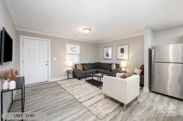 a living room with furniture and a refrigerator