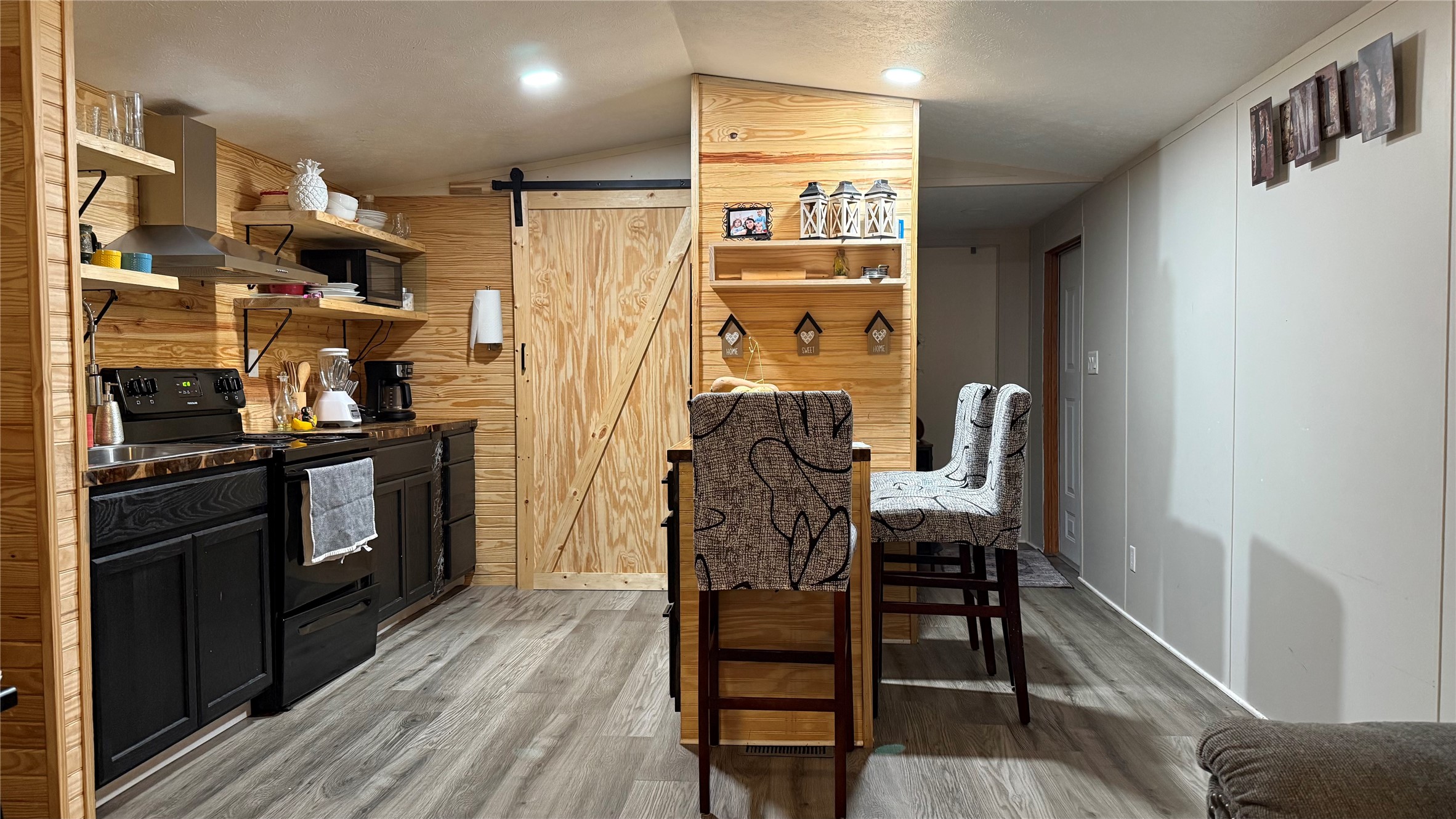 14348 West Ravine Run Willis, TX 77318 - Photo 8 of 15 a kitchen with stainless steel appliances a refrigerator a stove a sink and a dining table with wooden floor