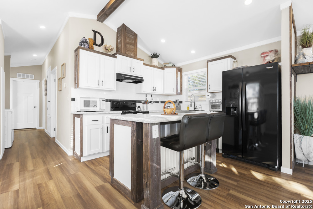 164 Private 1523 Bandera, TX 78003 - Photo 7 of 44 a kitchen with stainless steel appliances granite countertop a refrigerator a stove a sink and a dining table with wooden floor