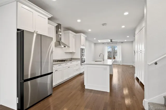 a kitchen with stainless steel appliances a refrigerator and a stove top oven