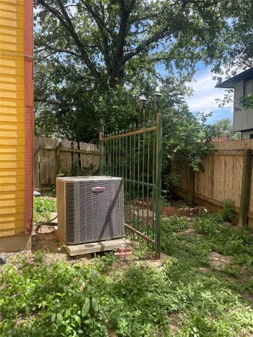 a view of backyard with wooden fence and a large tree