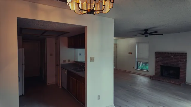 a view of hallway with wooden floor and a fireplace