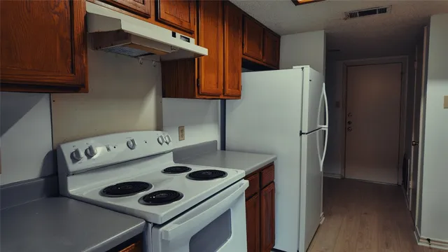 a kitchen with a refrigerator and a stove