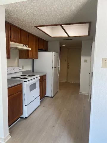 a kitchen with a refrigerator and a stove top oven