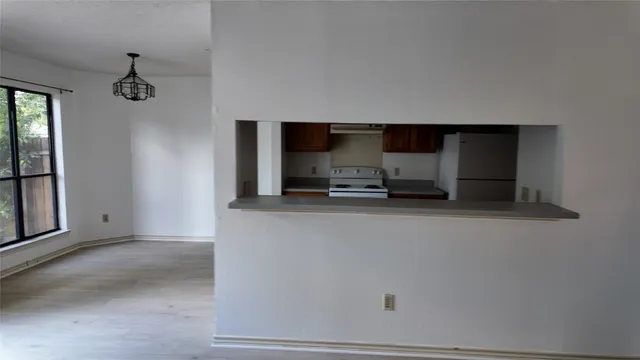 a living room with a refrigerator and a window