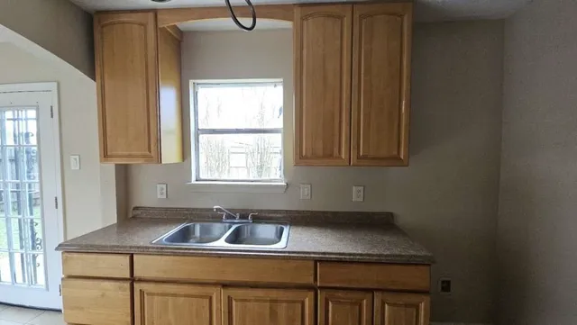 a kitchen with a sink a window and cabinets