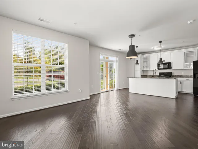 a view of a kitchen with a sink wooden floor and a window