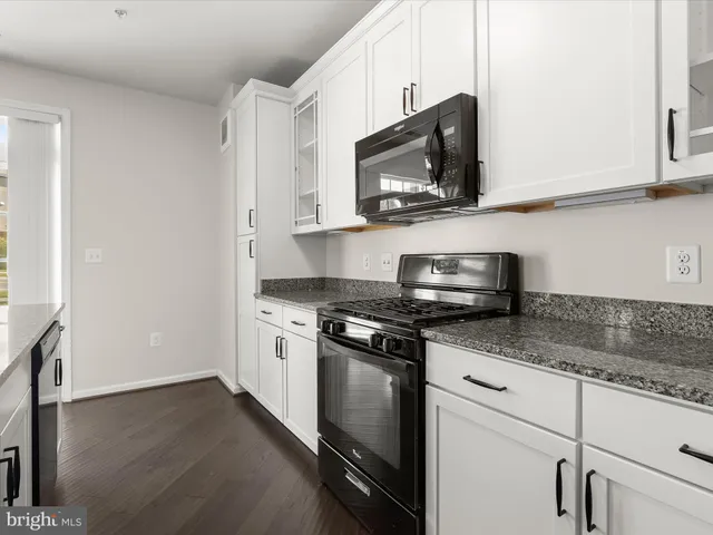 a kitchen with stainless steel appliances granite countertop a stove a microwave and a sink