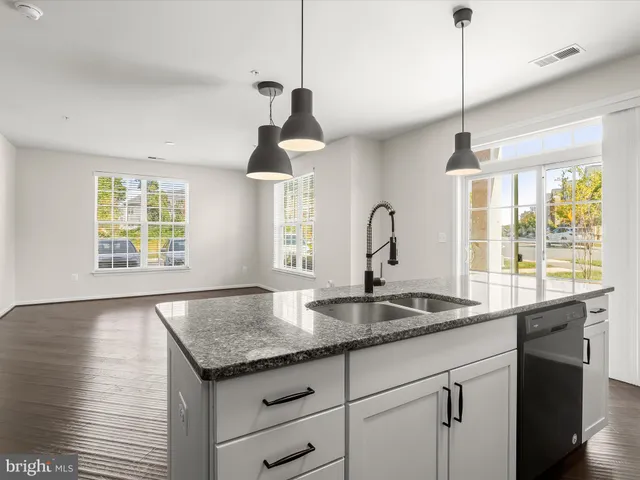 a kitchen with a sink a center island and a window