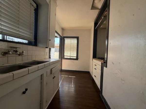 a kitchen with granite countertop a sink and cabinets
