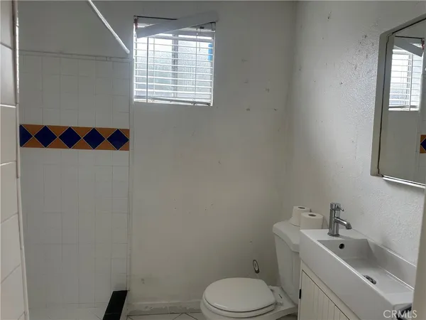 a white toilet sitting next to a white sink and vanity