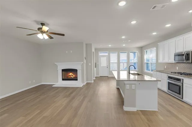 a view of a kitchen with a sink a microwave and cabinets