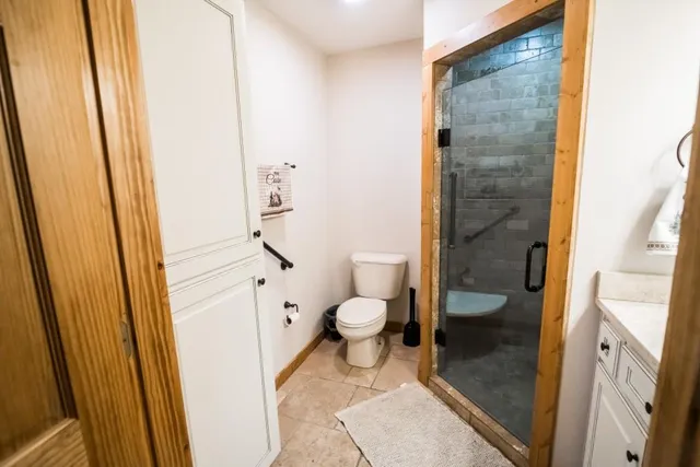 a bathroom with a granite countertop toilet a sink and a mirror