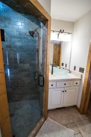 a bathroom with a double vanity sink a mirror and shower