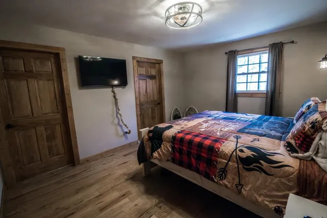a bed sitting in a bedroom next to a window with pc on the wall