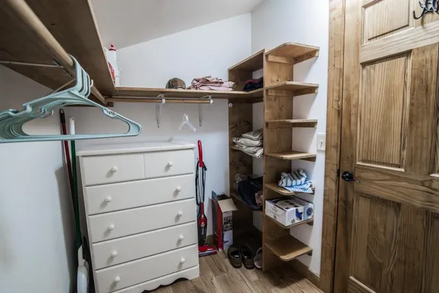 a view of walk in closet with clothes and shoes