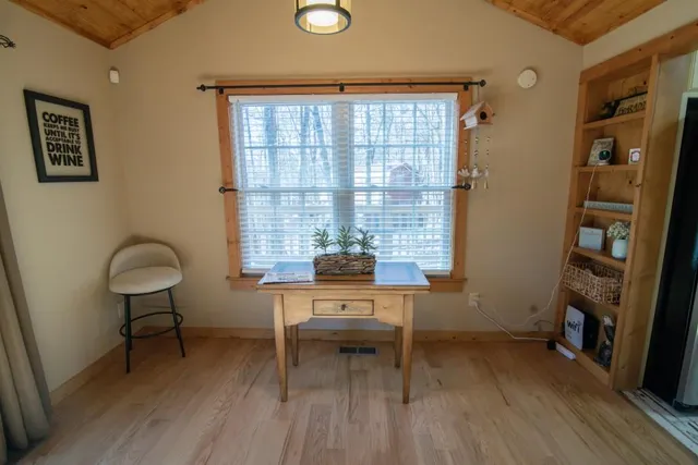 a view of a workspace with furniture and a window