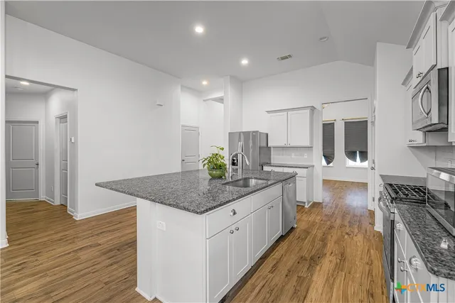 a open kitchen with stainless steel appliances granite countertop a lot of counter space and wooden floors