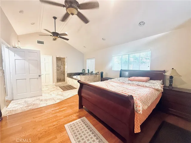 a spacious bedroom with a bed dresser and a window