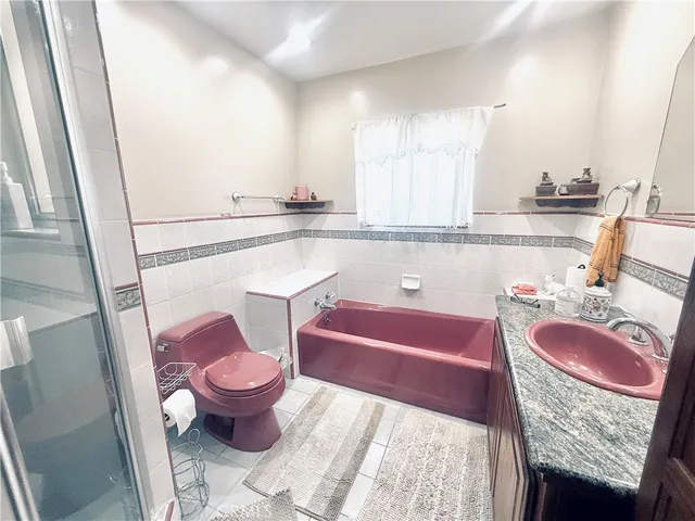 a bathroom with a granite countertop toilet a sink and a bathtub