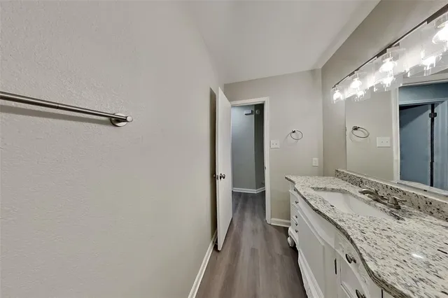 a bathroom with a granite countertop sink a toilet and shower
