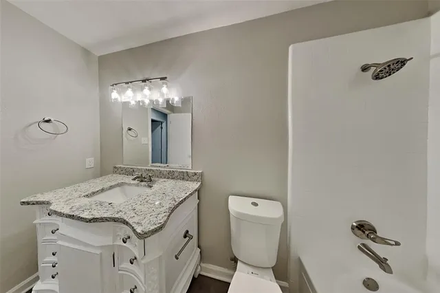 a bathroom with a granite countertop sink toilet and shower