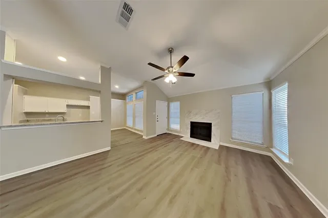 a view of empty room with wooden floor and fireplace