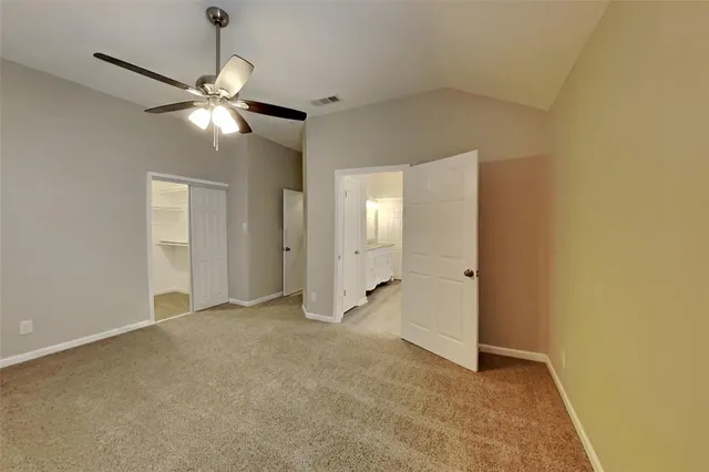 an empty room with closet and a chandelier fan