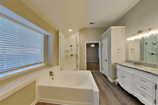 a spacious bathroom with a bathtub shower sink double and mirror