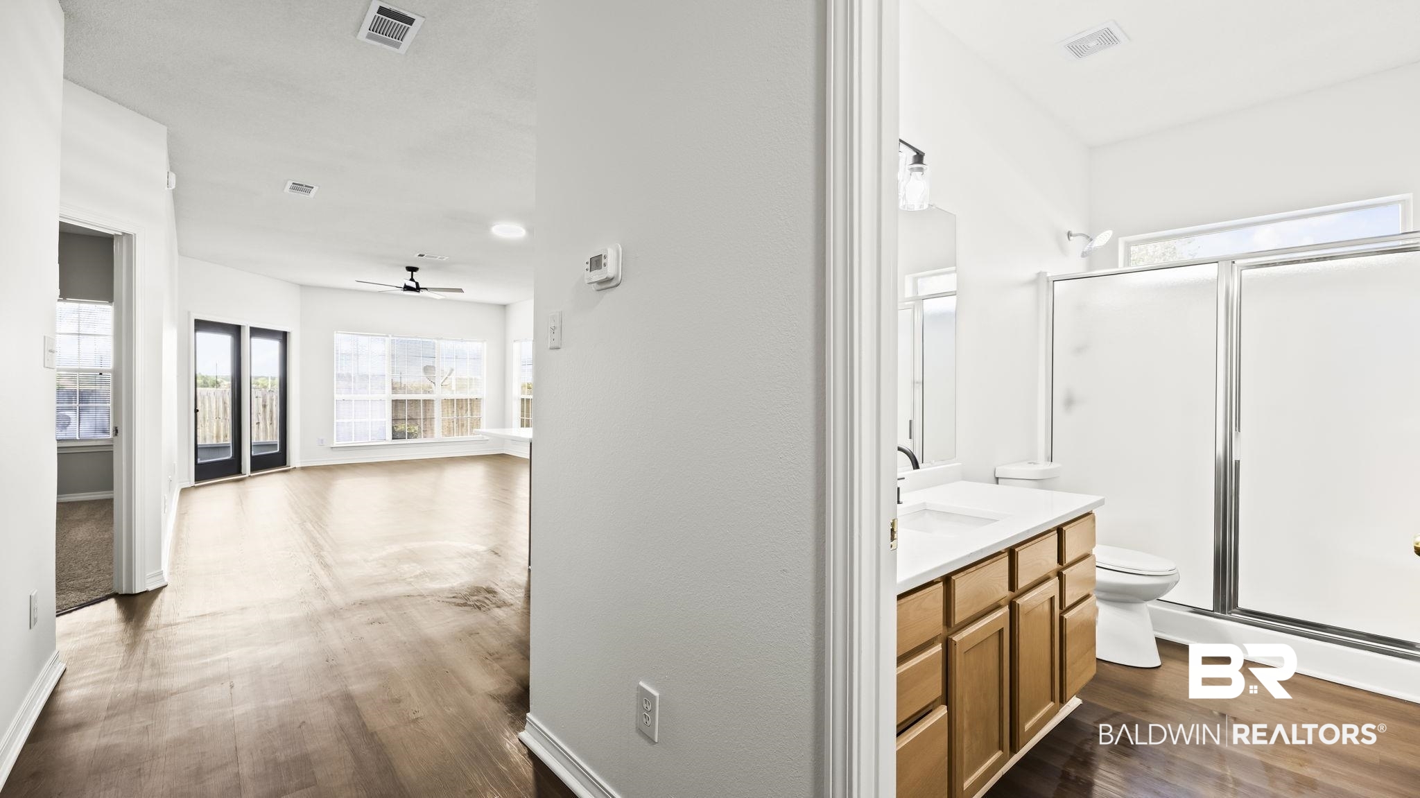 2651 South Juniper Street, Unit 705 Foley, AL 36535 - Photo 16 of 37 Bathroom featuring a light wood-finish vanity with a white countertop and a walk-in shower with frosted glass doors