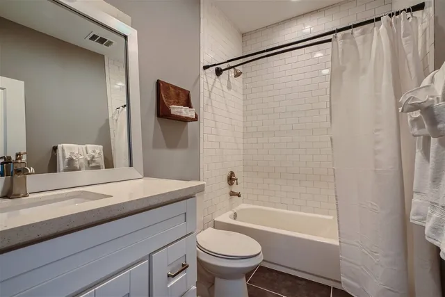 a bathroom with a sink a toilet a mirror and shower