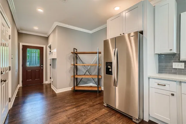a kitchen with stainless steel appliances a refrigerator and wooden floor