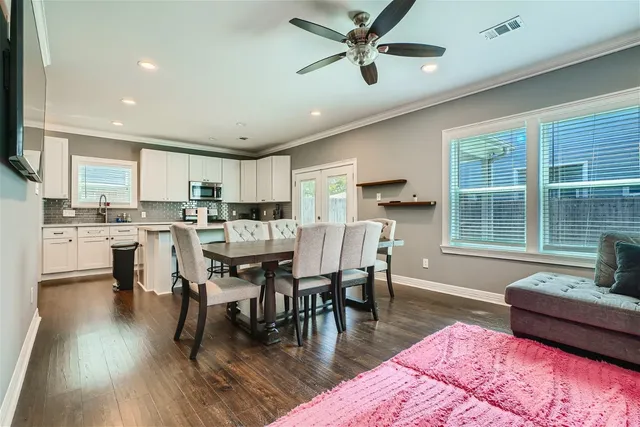 a living room with stainless steel appliances granite countertop furniture wooden floor and a kitchen view