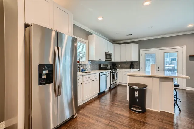a kitchen with a refrigerator a sink and cabinets