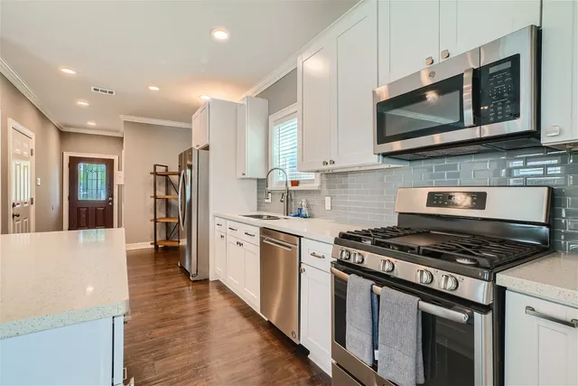 a kitchen with stainless steel appliances granite countertop a stove microwave sink and refrigerator