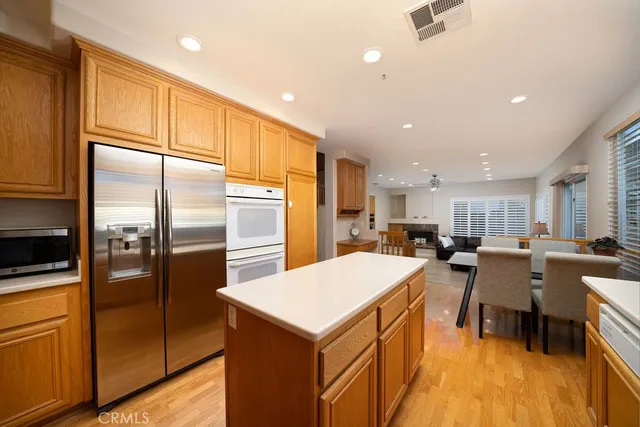 a kitchen with a refrigerator a sink dishwasher with a dining table and chairs