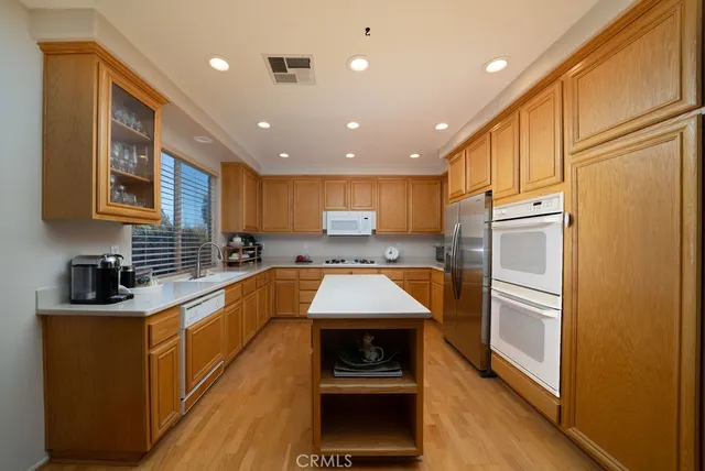 a kitchen with stainless steel appliances granite countertop a stove a sink and a refrigerator