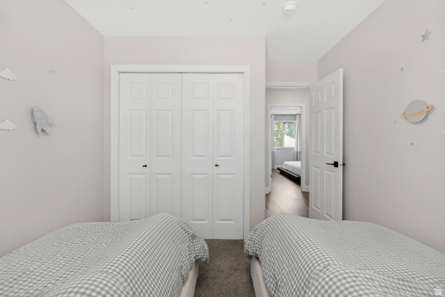 4752 South 4075th Street West Roy, UT 84067 - Photo 14 of 28 Bedroom featuring light-toned walls, bi-fold closet doors, and carpet flooring