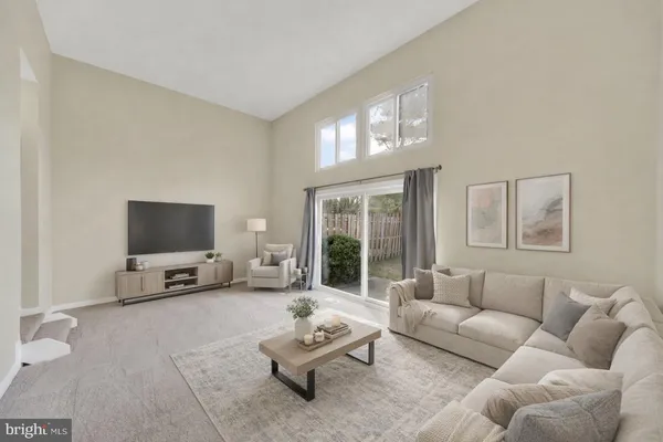 a living room with furniture and a flat screen tv with wooden floor