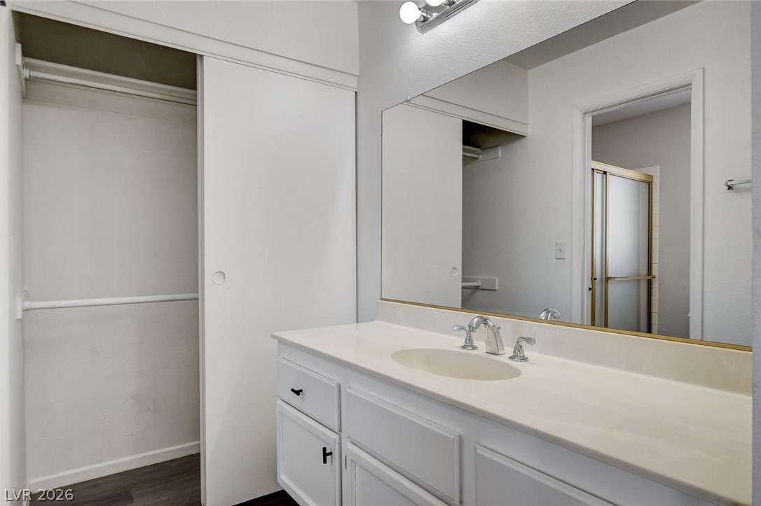 6209 Warm River Road Las Vegas, NV 89108 - Photo 29 of 39 A pristine vanity area showcases a single basin sink and full-width mirror, complemented by an adjacent closet.