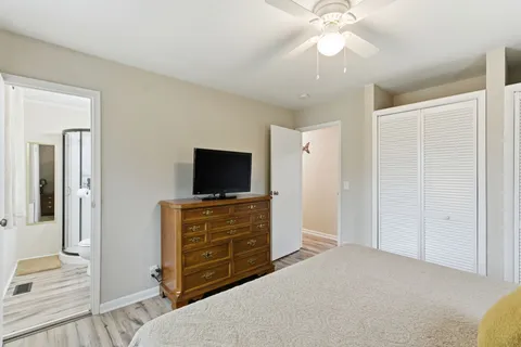 a bedroom with a bed and a flat tv screen on dresser